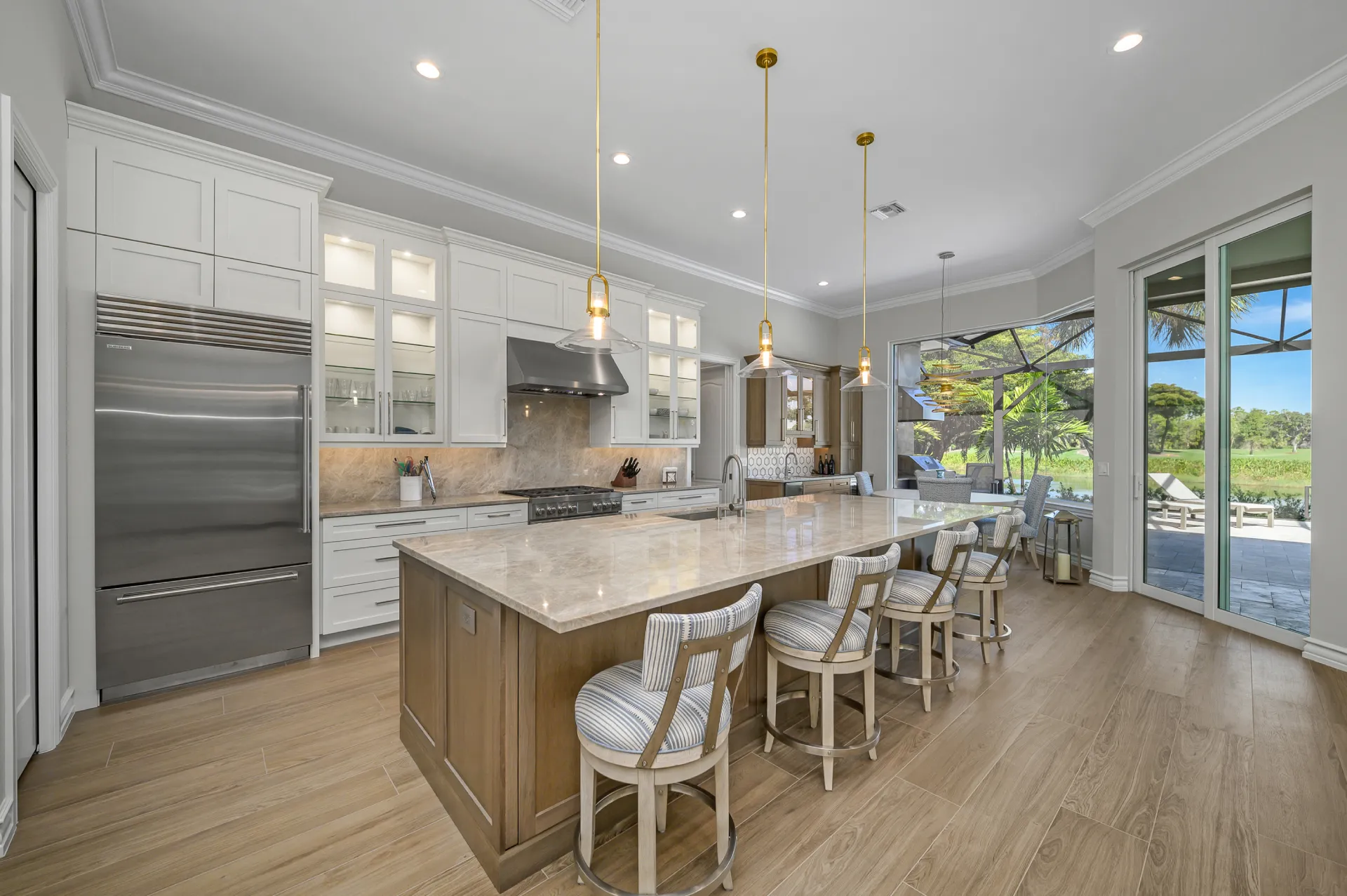 A modern kitchen featuring a central island and a cozy dining area with chairs and a table.